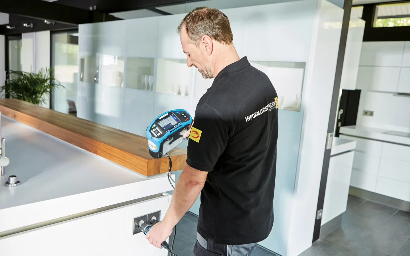 E-CHECK - Mitarbeiter prüft die Steckdosen in der Küche · Winter Elektro